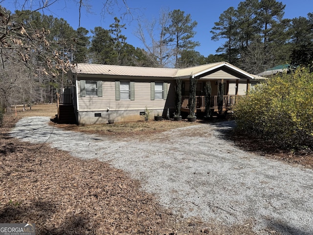 manufactured / mobile home featuring crawl space, a porch, metal roof, and gravel driveway