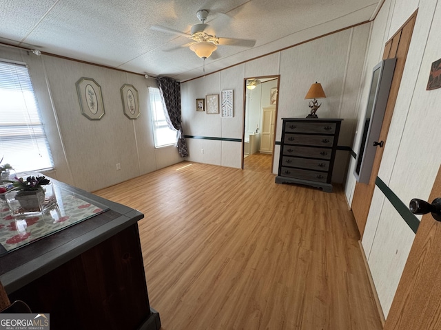 bedroom featuring crown molding, light wood-style flooring, lofted ceiling, and a textured ceiling