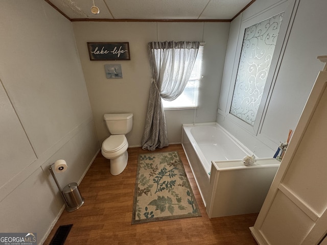 full bathroom featuring visible vents, crown molding, toilet, a garden tub, and wood finished floors