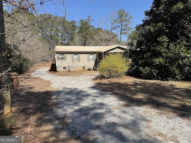 view of front of home featuring metal roof and crawl space