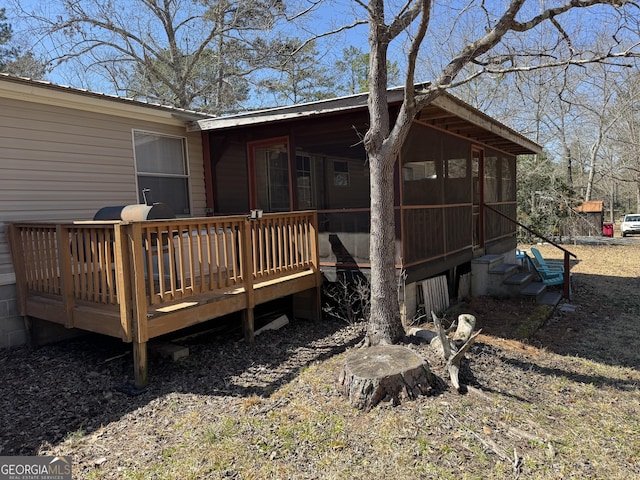 rear view of property with a wooden deck and a sunroom