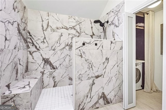 full bathroom featuring washer / clothes dryer, wood finished floors, and a marble finish shower