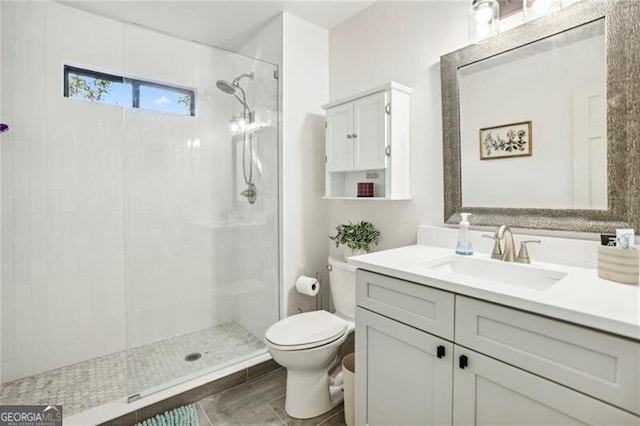 full bath with vanity, toilet, and a stall shower