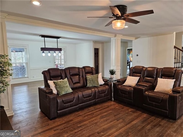 living area featuring dark wood finished floors, decorative columns, a ceiling fan, and ornamental molding