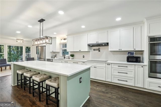 kitchen with plenty of natural light, white cabinets, stainless steel appliances, and dark wood-type flooring