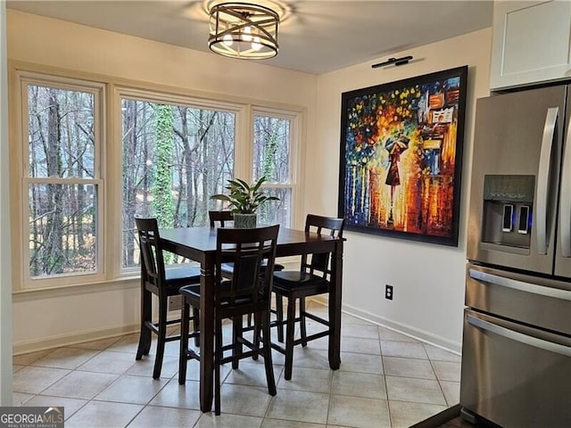 dining area featuring light tile patterned floors and baseboards