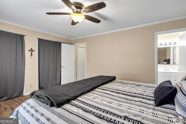 bedroom featuring a ceiling fan, wood finished floors, ensuite bathroom, and ornamental molding