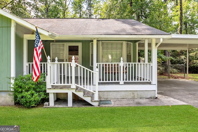 view of exterior entry featuring a lawn, a porch, concrete driveway, a shingled roof, and an attached carport