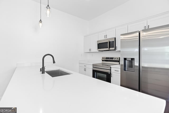 kitchen featuring a sink, hanging light fixtures, light countertops, white cabinets, and stainless steel appliances