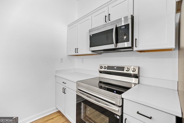 kitchen with white cabinets, appliances with stainless steel finishes, and light countertops