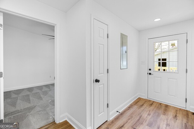 entryway with electric panel, baseboards, light wood-style floors, and recessed lighting