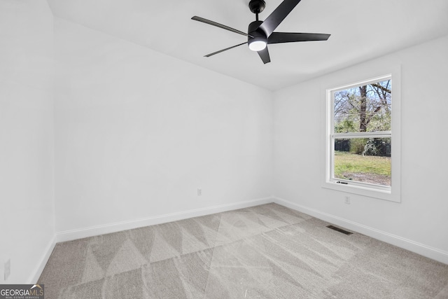 spare room with visible vents, light carpet, baseboards, and a ceiling fan