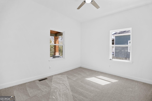 spare room with visible vents, baseboards, ceiling fan, and carpet flooring