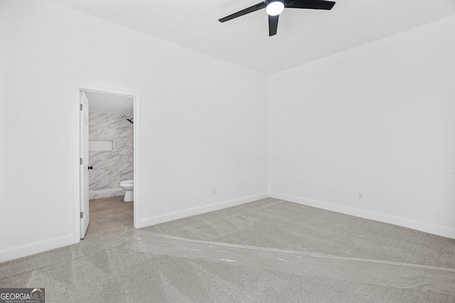 unfurnished bedroom with carpet flooring, a ceiling fan, baseboards, and connected bathroom