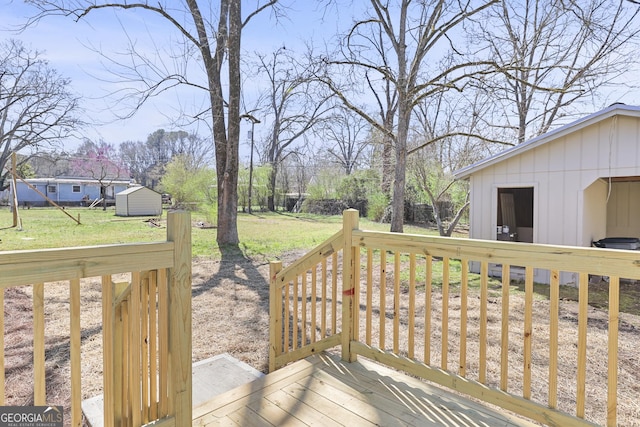 deck with a yard and an outdoor structure