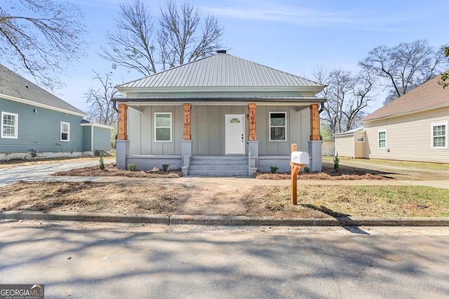 bungalow featuring a porch, board and batten siding, and metal roof