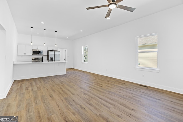 unfurnished living room with light wood finished floors, visible vents, baseboards, recessed lighting, and a ceiling fan