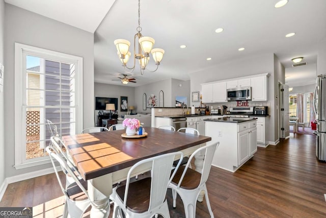 dining space featuring dark wood finished floors, ceiling fan with notable chandelier, and recessed lighting