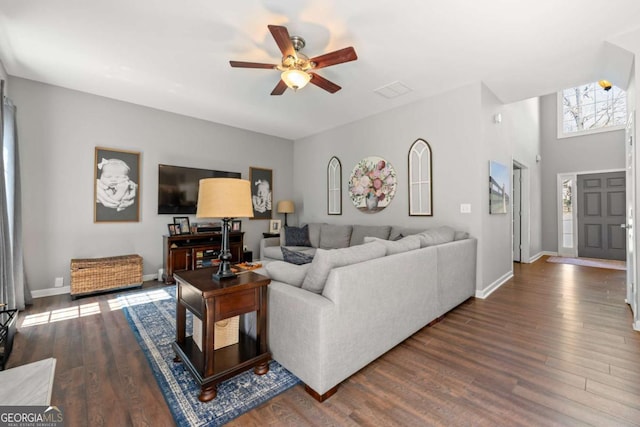 living area featuring ceiling fan, baseboards, and dark wood finished floors