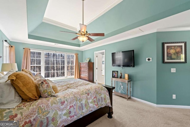 bedroom featuring a ceiling fan, carpet, baseboards, a tray ceiling, and ornamental molding