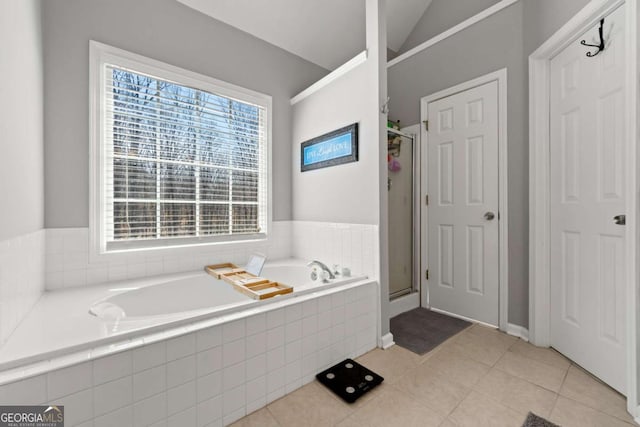 full bath with tile patterned flooring, a shower stall, a bath, and vaulted ceiling