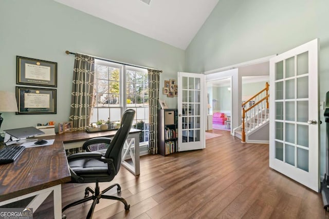 office with wood finished floors, french doors, and high vaulted ceiling