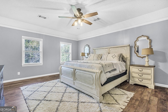 bedroom with dark wood-style floors, visible vents, and baseboards