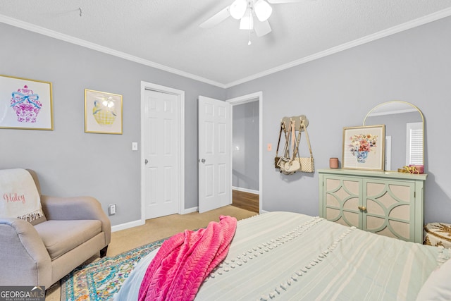 carpeted bedroom featuring ceiling fan, a textured ceiling, baseboards, and ornamental molding