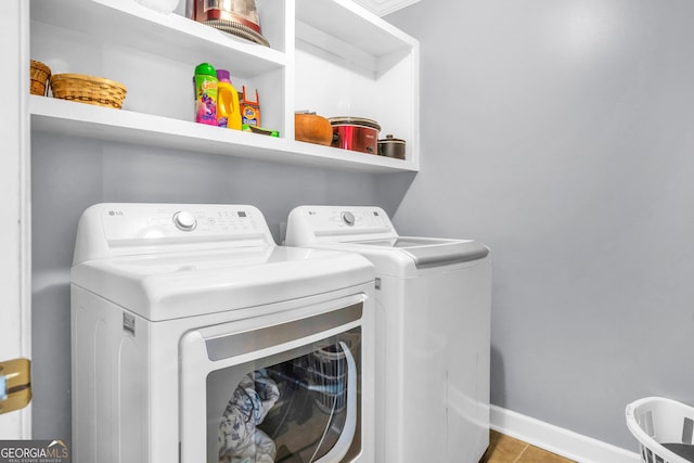 clothes washing area with laundry area, baseboards, independent washer and dryer, and tile patterned floors