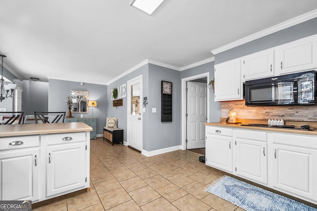 kitchen with black appliances, ornamental molding, tasteful backsplash, white cabinets, and light countertops