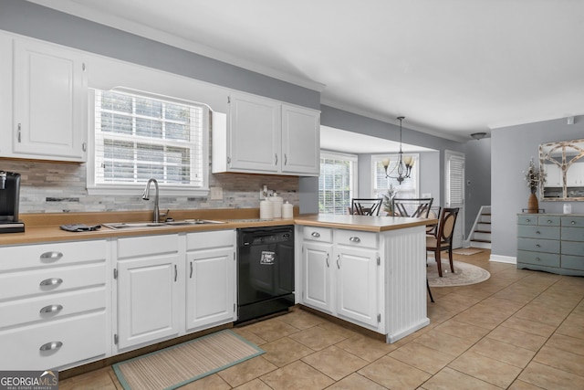 kitchen with a peninsula, an inviting chandelier, a sink, decorative backsplash, and black dishwasher