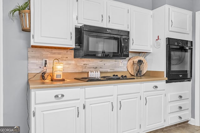 kitchen featuring decorative backsplash, white cabinetry, black appliances, and light countertops