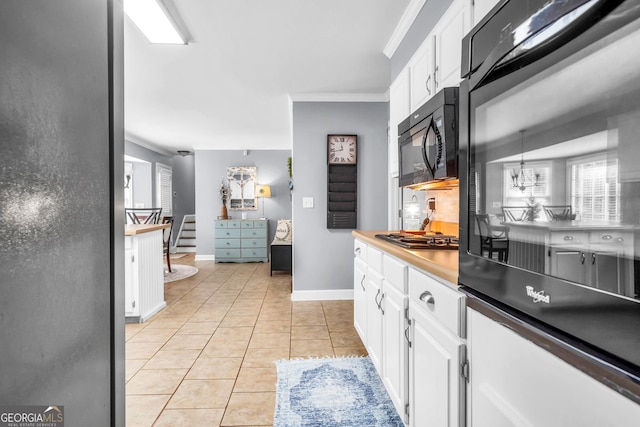 kitchen featuring black appliances, white cabinets, light tile patterned floors, and ornamental molding