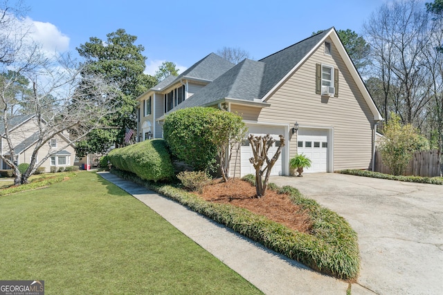 view of home's exterior featuring a shingled roof, fence, concrete driveway, a garage, and a yard