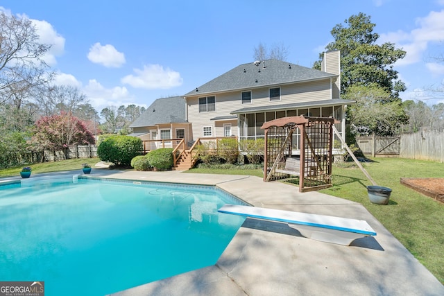 view of swimming pool featuring a fenced backyard, a lawn, a sunroom, and a wooden deck