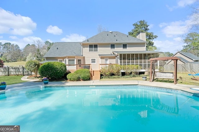 view of swimming pool featuring a fenced in pool, fence, a deck, and a sunroom