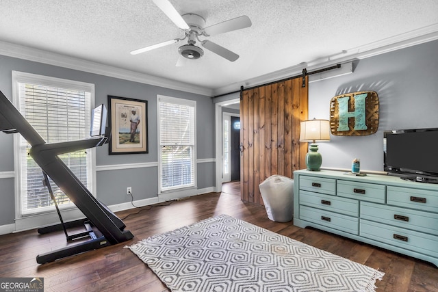 interior space featuring crown molding, dark wood finished floors, a barn door, a textured ceiling, and a ceiling fan