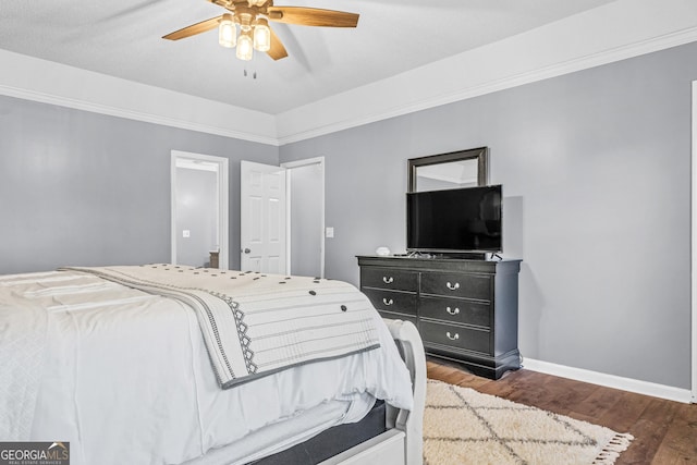 bedroom with a ceiling fan, wood finished floors, and baseboards