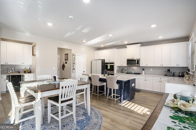 dining area with wine cooler, recessed lighting, and light wood-style floors