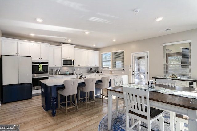 dining room with recessed lighting, visible vents, and light wood-type flooring