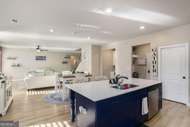 kitchen with a sink, blue cabinetry, stainless steel dishwasher, light wood finished floors, and ceiling fan