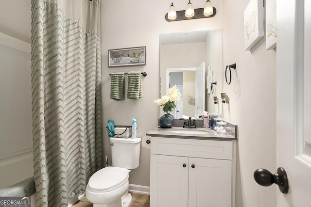 bathroom with toilet, curtained shower, and vanity