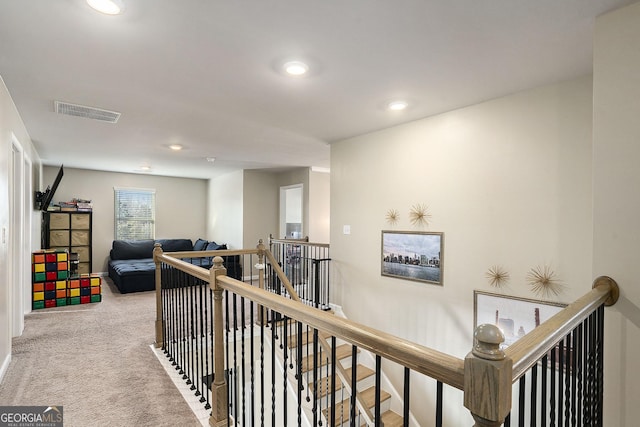 hallway with recessed lighting, visible vents, an upstairs landing, and carpet