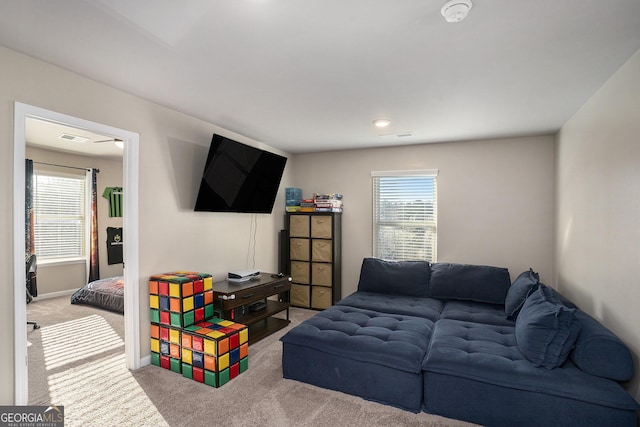 living area featuring carpet flooring, visible vents, and a wealth of natural light