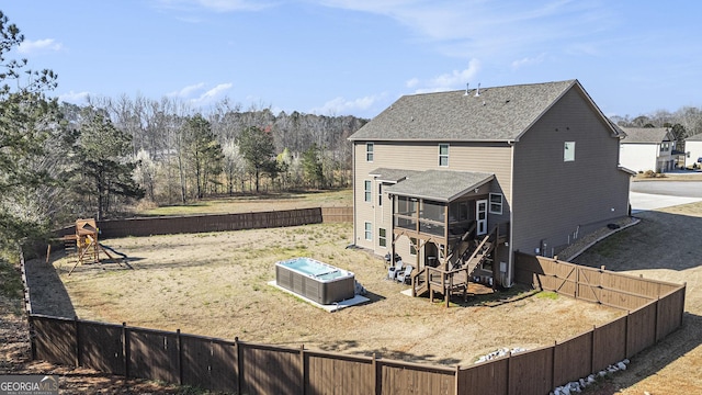 back of house featuring a deck, a fenced backyard, a sunroom, stairs, and a hot tub