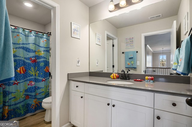 full bath featuring visible vents, toilet, curtained shower, wood finished floors, and vanity