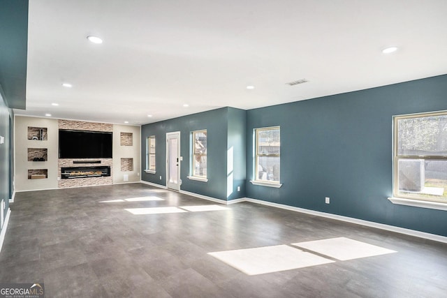 unfurnished living room featuring visible vents, recessed lighting, a fireplace, and baseboards