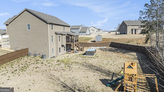 exterior space featuring a residential view, a playground, central AC, and fence