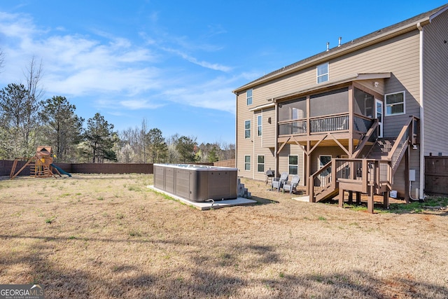 rear view of house with a playground, stairway, central AC unit, a fenced backyard, and a sunroom