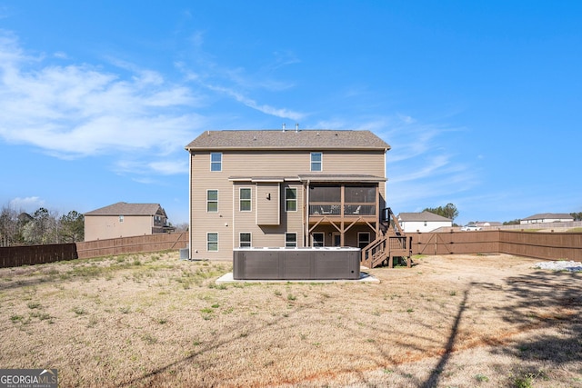 rear view of house featuring a fenced backyard, stairs, and a sunroom